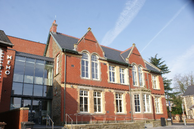External shot of Newbridge Memo. Large heritage building in red brick.