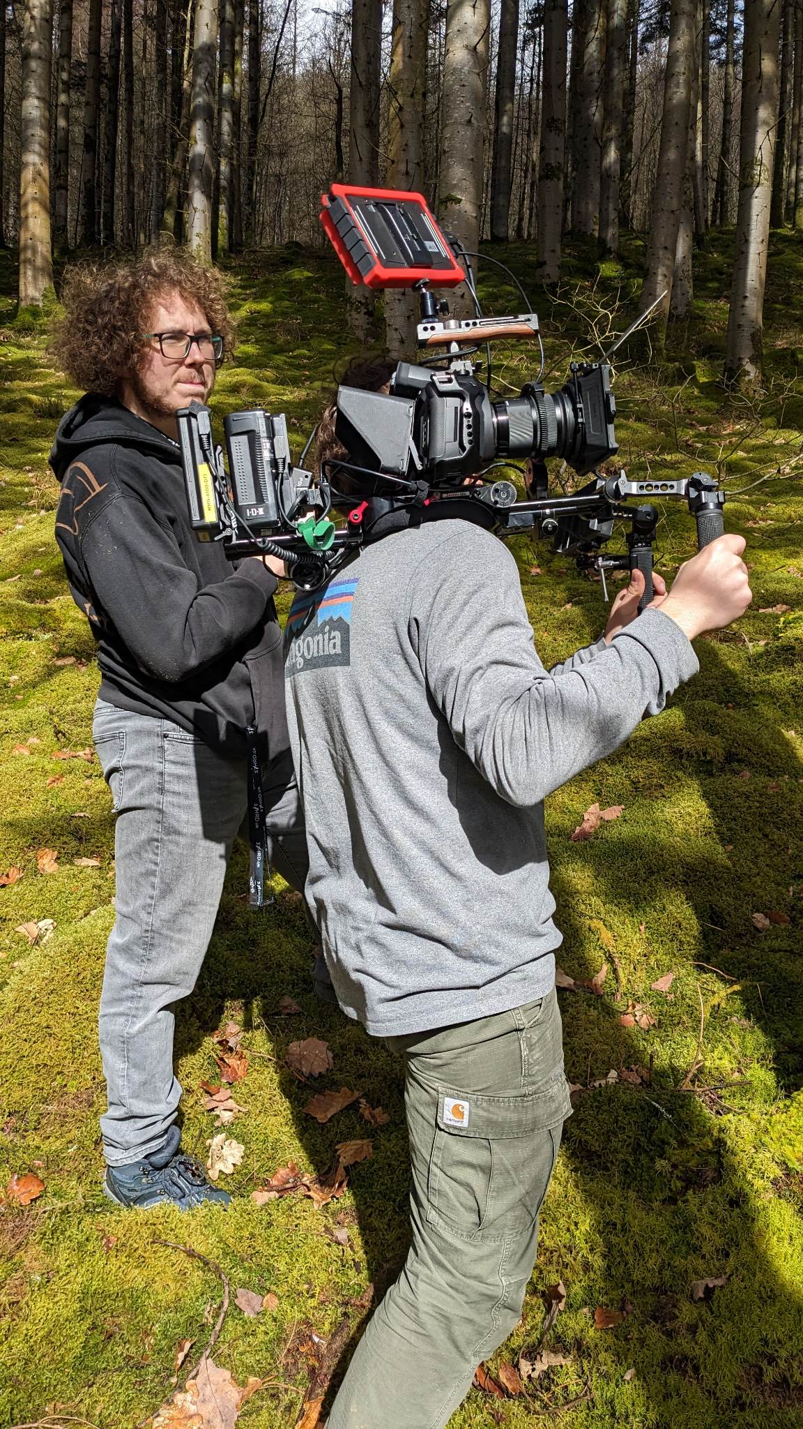 Behind the scenes of 'Ode to Moss' (2023). Matthew is operating the follow focus on location in mossy woods near Ysbyty Ystwyth. Solomon, camera operator, is operating handheld next to him.