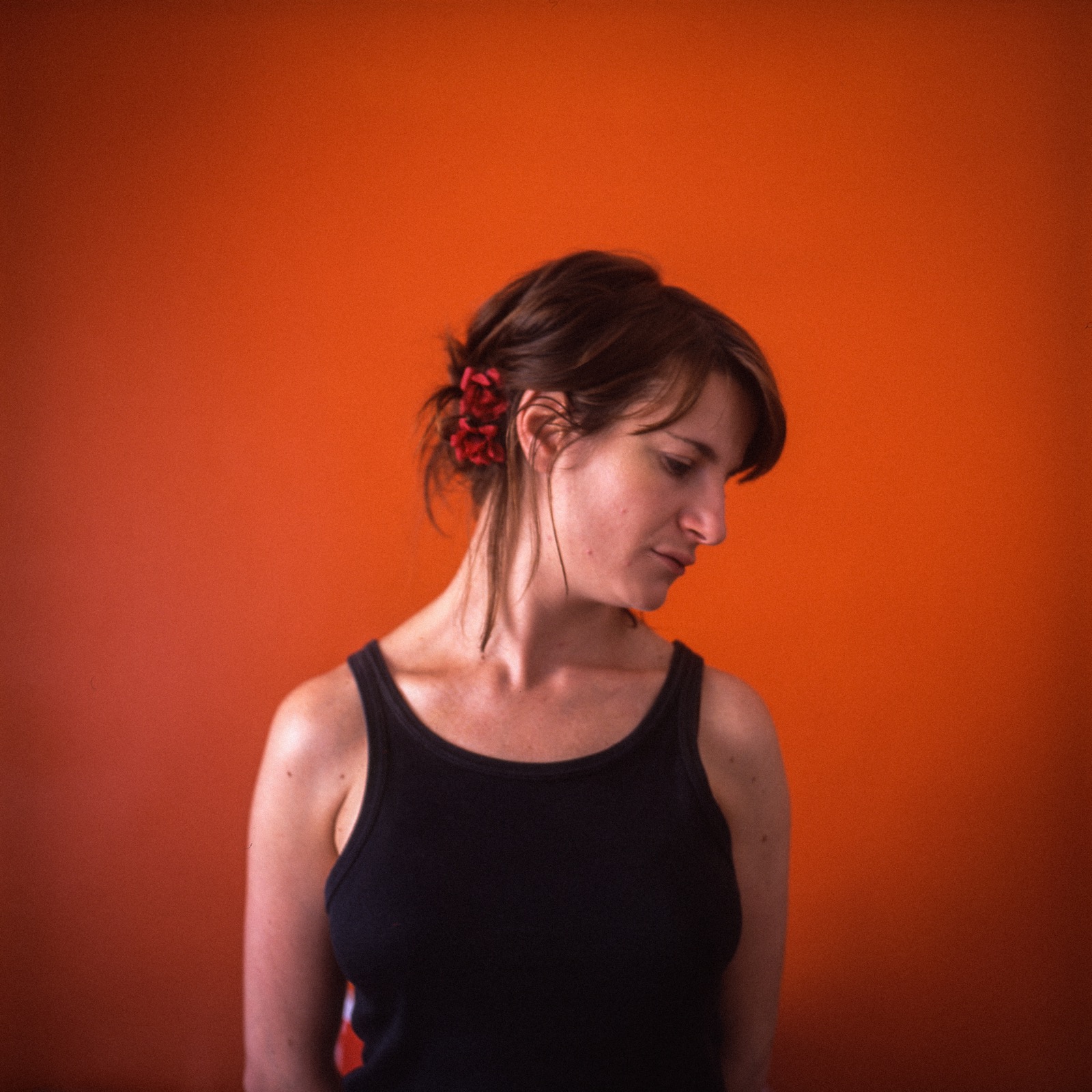 Portrait of a young woman with an orange background.