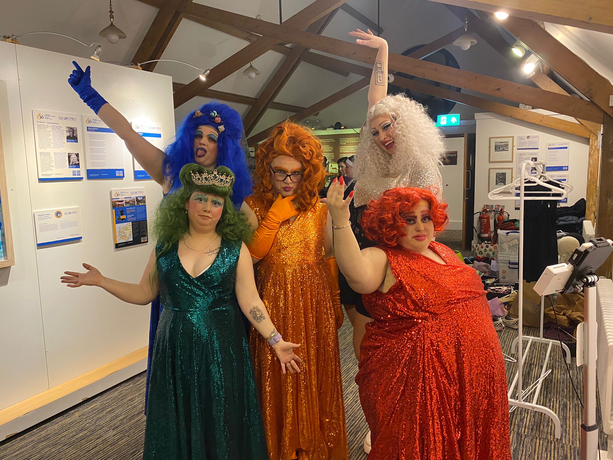 Members of the house of deviant in drag outfits made from different coloured sequin gowns, with matching coloured wigs.