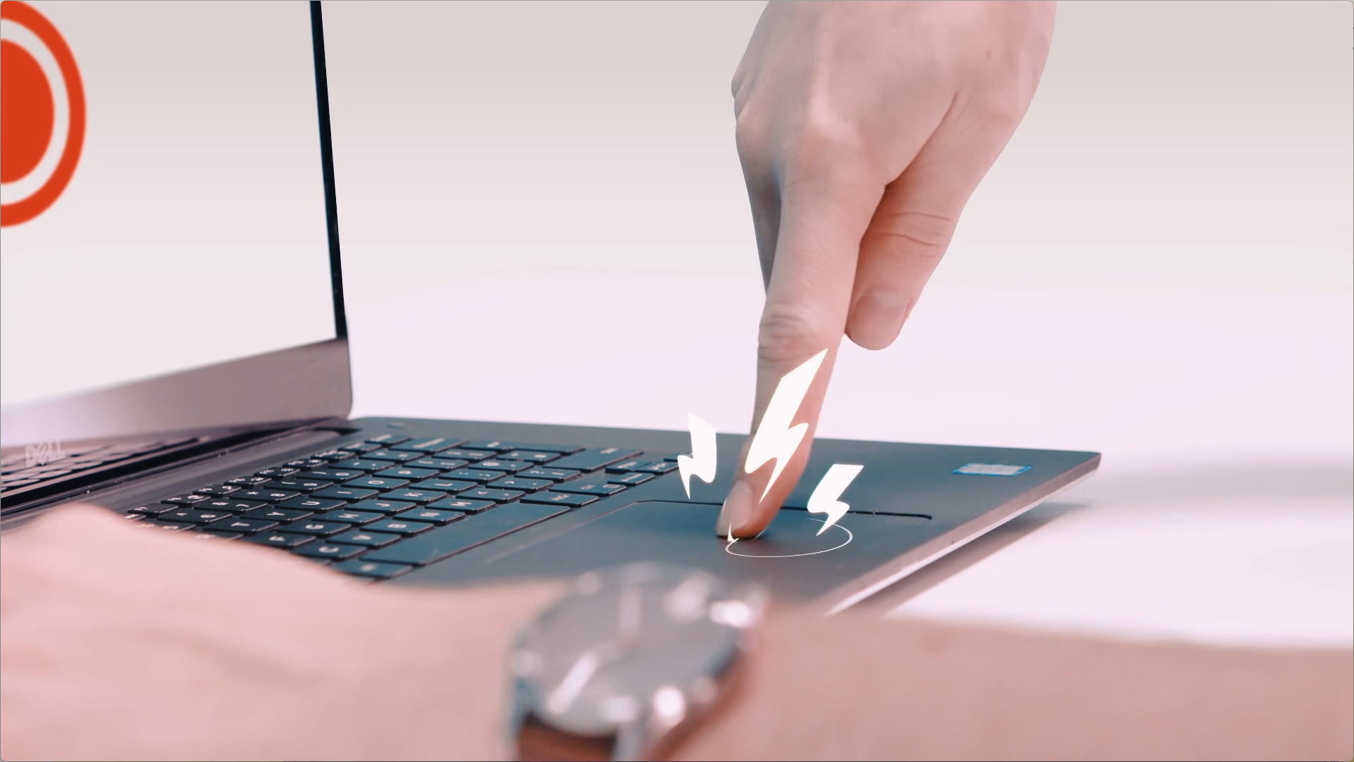 Live-action shot of a person pressing a laptop trackpad with animated lightning bolt graphics added to indicate action or feedback.