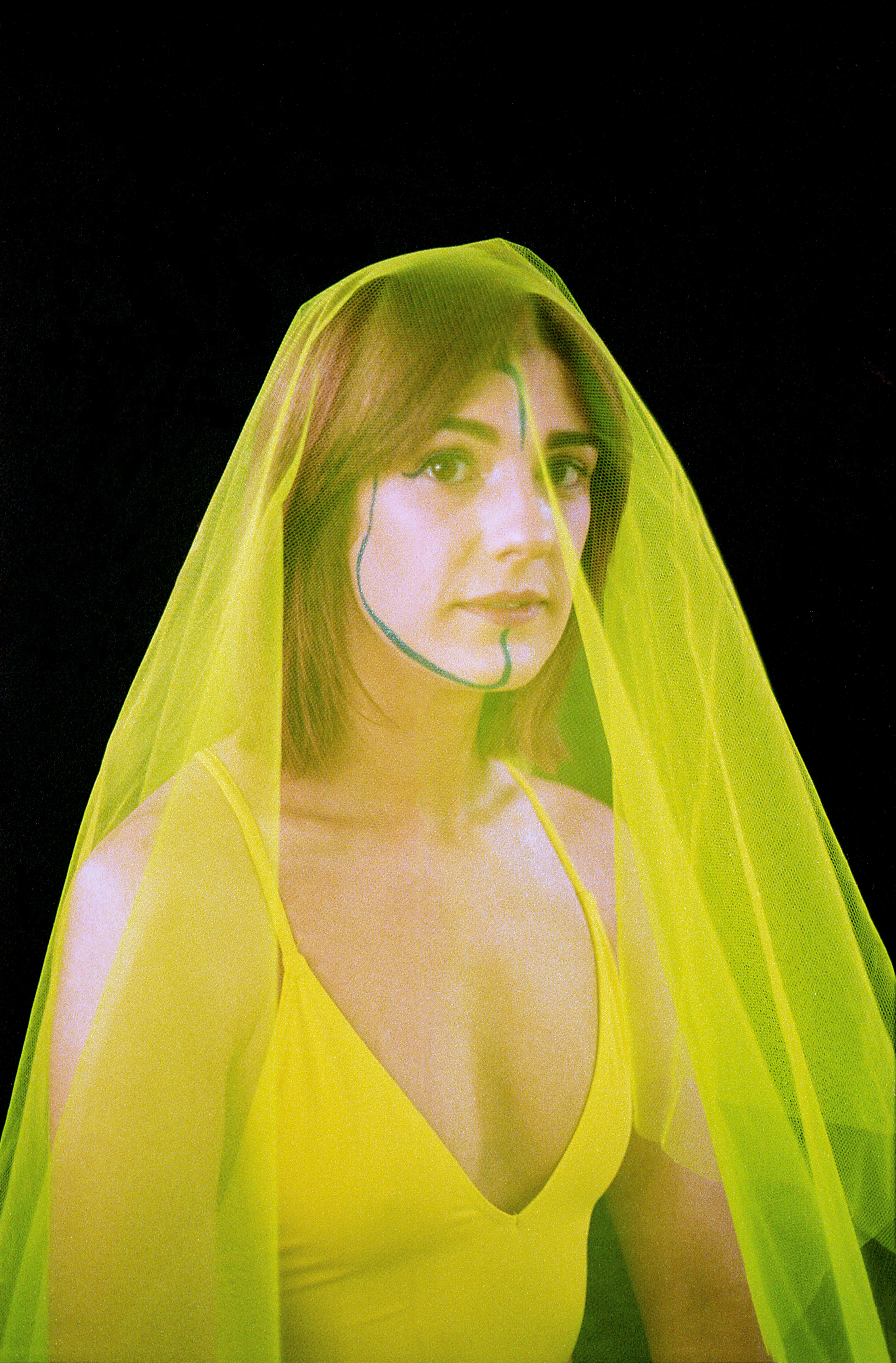 Ani Glass in yellow veil againt black backdrop