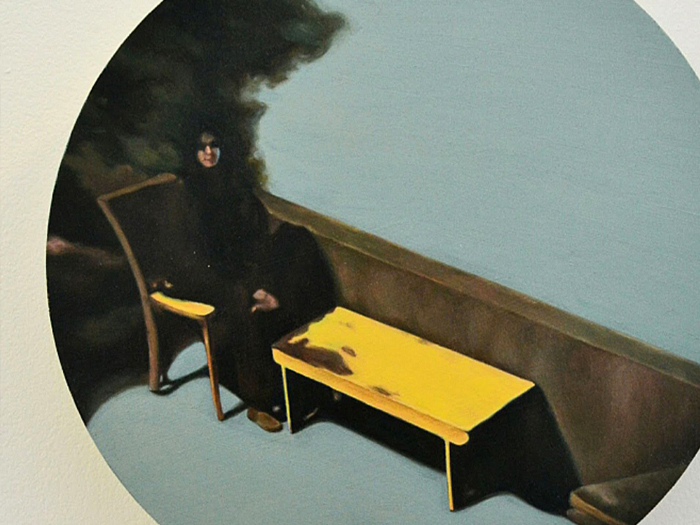 A circular painting of person sitting in a chair next to a yellow table