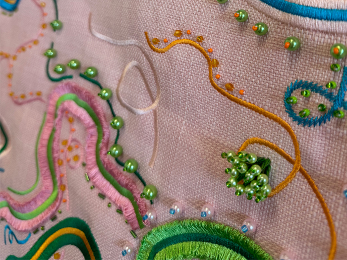 A close-up photo of an embroidered and beaded artwork
