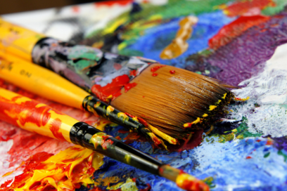 An image of colourful paint with brushes 