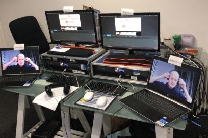 Duncan's desk during a live event which includes computer screens, tablets and keyboards