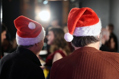 two men facing away from the camera in Santa hats